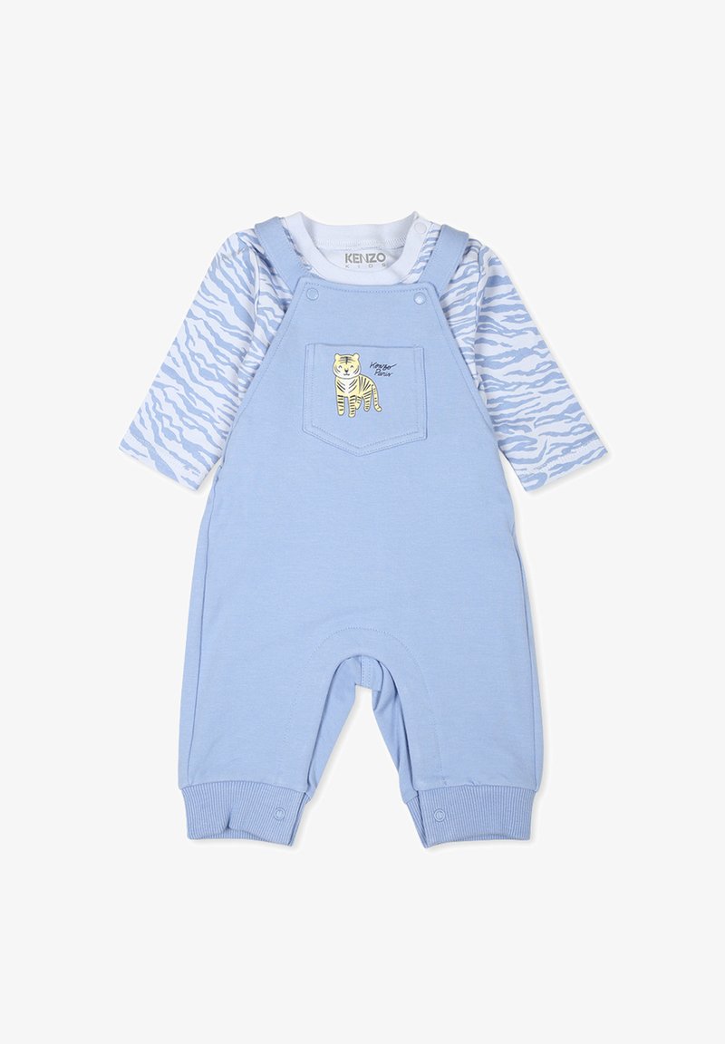 Blauwe katoenen overall met een zak met een geel tijgerontwerp. Lange mouwen top in het wit met blauwe abstracte patronen. Zachte textuur.