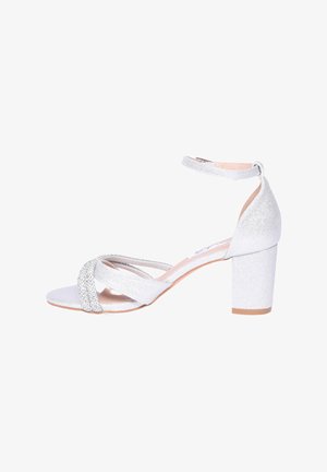 Sandalo open-toe glitter argento con tacco a blocco, caratterizzato da cinturini incrociati e una cinghia alla caviglia regolabile. Texture liscia, design elegante.