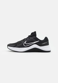Zapatilla deportiva negra con parte superior de malla, media suela texturizada blanca y un prominente logo de Nike en el costado. Diseño de punta redondeada.