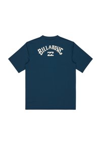 Camiseta de manga corta azul marino hecha de un tejido suave, con un logotipo blanco de "BILLABONG" en un diseño arqueado en la parte posterior.