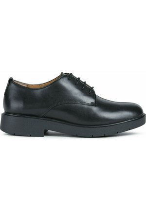 Zapatos de cuero negro con cordones, con un acabado suave, punta redonda y una suela de goma negra gruesa. Presenta detalles de costura sutiles.