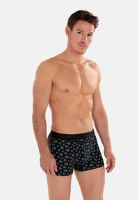 Schwarze Boxershorts mit einem mehrfarbigen Sternenexplosionsmuster, die sich dem Körper anpassen, mit einem weichen Bund, der das Markenlogo zeigt.