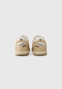 Sneaker beige con materiale in rete e camoscio, forma arrotondata, marchio visibile e collo imbottito per il massimo comfort. Suola in gomma con scanalature.