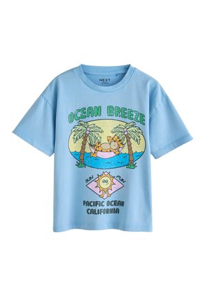 Light blue short-sleeve shirt with cartoon tiger relaxing in a hammock between palm trees, text "Ocean Breeze" and "Pacific Ocean California."