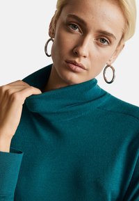 Türaqua Rollkragenpullover aus weichem Stoff, mit gerippten Kragen und Bündchen, glatter Textur und tailliertem Schnitt.