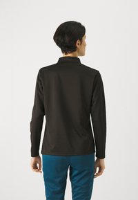 Zwarte pullover met lange mouwen en kraag, gemaakt van soepel materiaal. Heeft een relaxte fit en een minimalistisch ontwerp, zonder zichtbare patronen of accenten.
