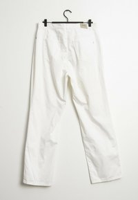 Vita bomullsshorts som visas bakifrån, med en rak bendesign, två bakfickor och en liten varumärkesetikett nära midjefästet.