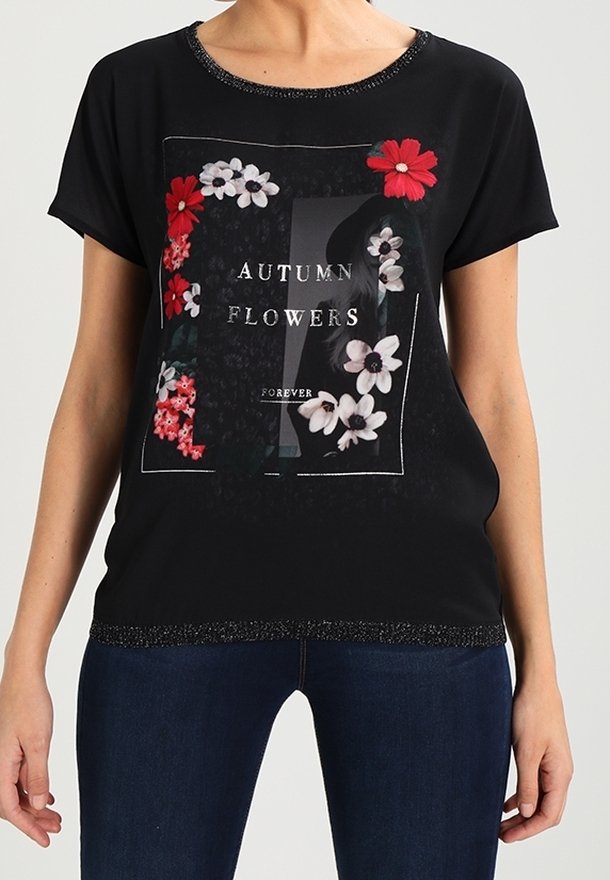 Top negro de manga corta con un diseño gráfico floral que presenta flores rojas y blancas, texto, y un cuello y dobladillo texturizados.