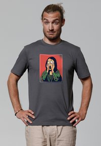 Graues T-Shirt mit kurzen Ärmeln, das ein Grafikdesign einer erschrockenen Person mit rotem Hintergrund zeigt. Hergestellt aus weichem, atmungsaktivem Stoff.