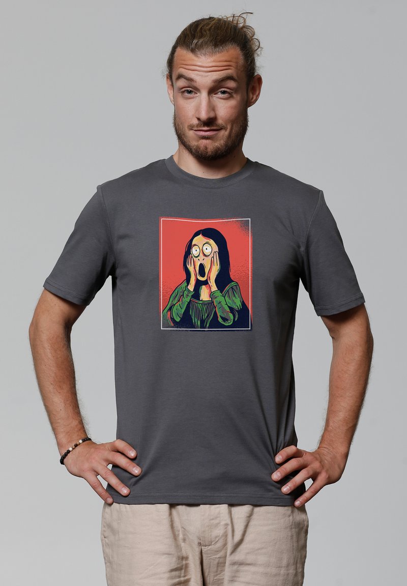 Graues T-Shirt mit kurzen Ärmeln, das ein Grafikdesign einer erschrockenen Person mit rotem Hintergrund zeigt. Hergestellt aus weichem, atmungsaktivem Stoff.