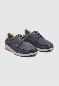 Zapatos de cuero azul marino con un diseño cosido, acentos grises, ojales de metal y una suela acolchada, que presentan una silueta casual de corte bajo.