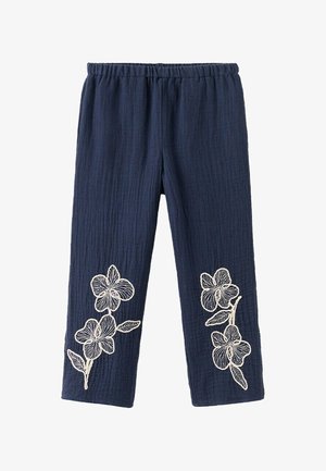 Pantaloni bleumarin cu textură, talie elastică și modele florale albe brodate aproape de partea inferioară a picioarelor pe ambele părți.