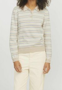 Pull-over beige rayé avec un col à revers, trois boutons, et des poignets et ourlet côtelés. Rayures verticales en bleu foncé et vert.