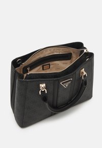 Sac à main noir Guess avec ferrures dorées, fermeture éclair sur le dessus, doubles poignées et doublure intérieure beige estampillée des logos Guess.