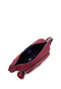 Liten vinröd crossbody-väska med öppen dragkedja, mörkt inre, framficka med dragkedja och fastsatt nyckelring med pom-pom-accessoar.