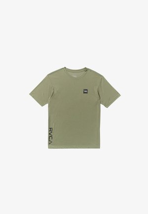 Oliwkowa koszulka z krótkim rękawem, wykonana z materiału bawełnianego, z kwadratowym czarnym logo na piersi i pionowym czarnym napisem po boku.