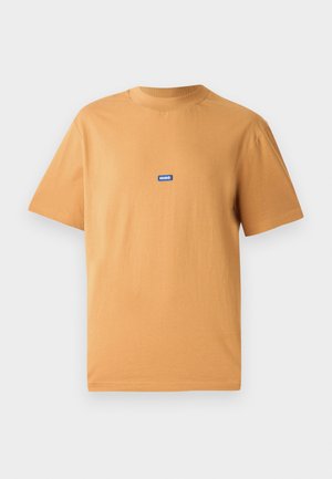 Oransje bomull T-skjorte med rund hals og korte ermer, med en liten blå "HUGO" logo-lapp på brystet. Glatt tekstur.