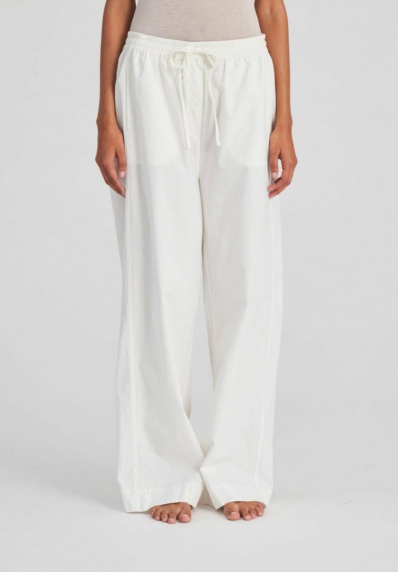 White, lightweight, wide-leg pants with an elastic waistband, featuring a drawstring. The fabric appears smooth and slightly sheer.