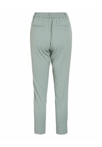 Vaaleanvihreät housut, joissa on joustava vyötärö, kapenevat lahkeet ja kaksi takataskua. Suorastaan sileä kangas ilman näkyviä kuvioita tai varusteita.