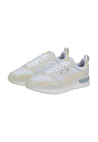 Hvide sneakers i mesh og ruskind, med gule detaljer, tekstureret sål og snørebåndsdesign. Puma-logo på siden.