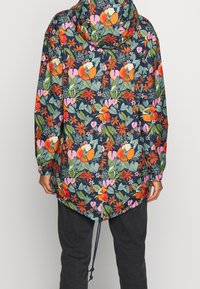 Kurtka z kapturem w kwiatowy wzór na ciemnogranatowym tle z czerwonymi, różowymi i zielonymi kwiatami, z elastycznymi mankietami i ściągaczem u dołu.