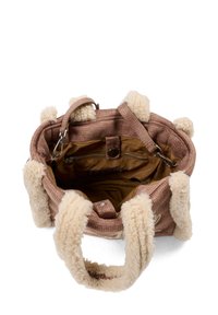 Borsa a mano in tessuto marrone con manici in peluche crema, dotata di interni foderati, tasca con zip e accenti decorativi rotondi. Design con apertura superiore.
