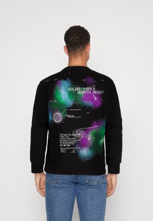 Sudadera negra con un estampado de galaxia multicolor en la parte posterior, que incluye texto y gráficos en blanco, así como puños y dobladillos acanalados.