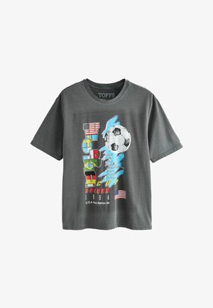 Szara koszulka z kolorowym napisem „WORLD CUP SOCCER 1994”, piłką nożną, grafiką flagi USA oraz listą miast gospodarzy na przodzie.