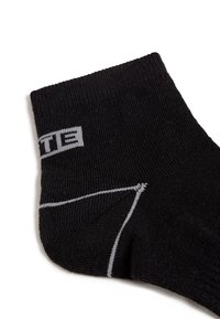 Calcetín negro hasta el tobillo con textura acanalada, logo gris y detalles en gris claro, que cuenta con talón y puntera reforzados para mayor durabilidad.
