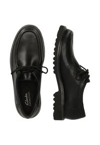 Scarpe in pelle nera con punta rotonda, design con lacci, suole testurizzate e cuciture visibili. Presentano un collo imbottito per il comfort.