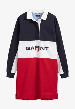 Bawełniana sukienka w stylu rugby z motywem w kolorze bloków: granatowym, białym i czerwonym. Posiada kołnierzyk, zapięcie na guziki oraz detal z logo.
