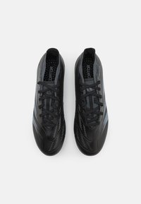 Zwarte sport schoenen met een slank ontwerp, voorzien van een gestructureerde bovenkant, dunne strepen en zwarte veters. Rubberen zool met een gladde afwerking.