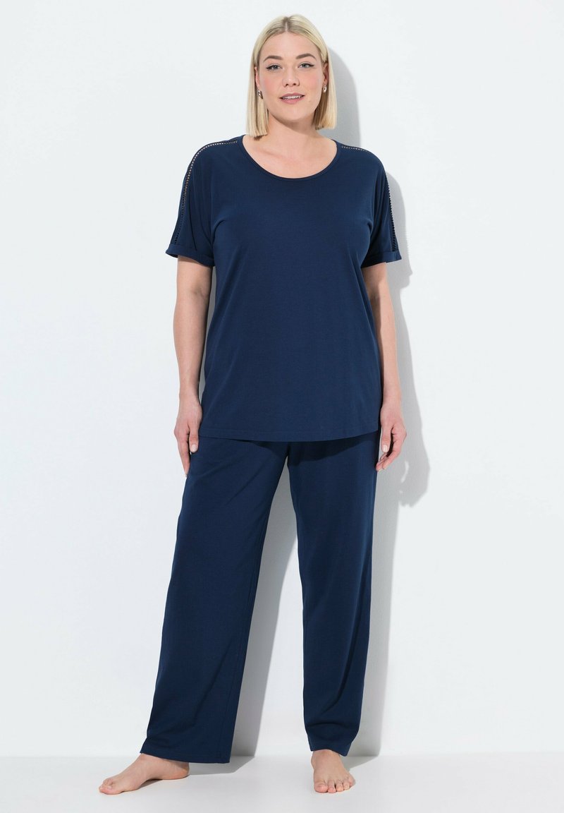 Marineblauw tweedelig loungewear-set bestaande uit een top met korte mouwen en een ronde halslijn, en loszittende broeken, gemaakt van zachte stof.