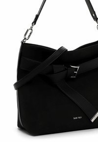 Borsa nera realizzata in materiale morbido e strutturato, con una tracolla in pelle annodata, dettagli in metallo e un logo di marca argentato.