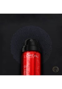Bombe de spray rouge et noire avec le logo L'Oréal Paris, entourée de gouttelettes d'eau noires en cercle sur un fond sombre.