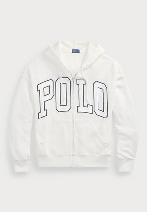 White zip-up hoodie made of soft fabric, featuring a large navy "POLO" graphic on the front. It has two front pockets and a drawstring hood.