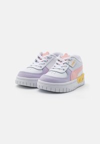 Zapatillas deportivas que presentan cuero blanco con acentos en rosa y púrpura, suela de goma texturizada y diseño de puntera perforada. Detalle notable en el talón en color amarillo.