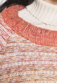 Gebreide trui met een geribde kraag in oranje en roomkleur, een gestructureerd lichaam met horizontale strepen, gemaakt van een wolmix, met verschillende kleuren.