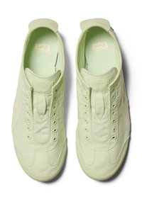 Světle zelené tenisky s hladkým povrchem, designem na nazouvání a tónovým prošíváním. Mají kulaté okénka a polstrovaný jazyk pro větší pohodlí.