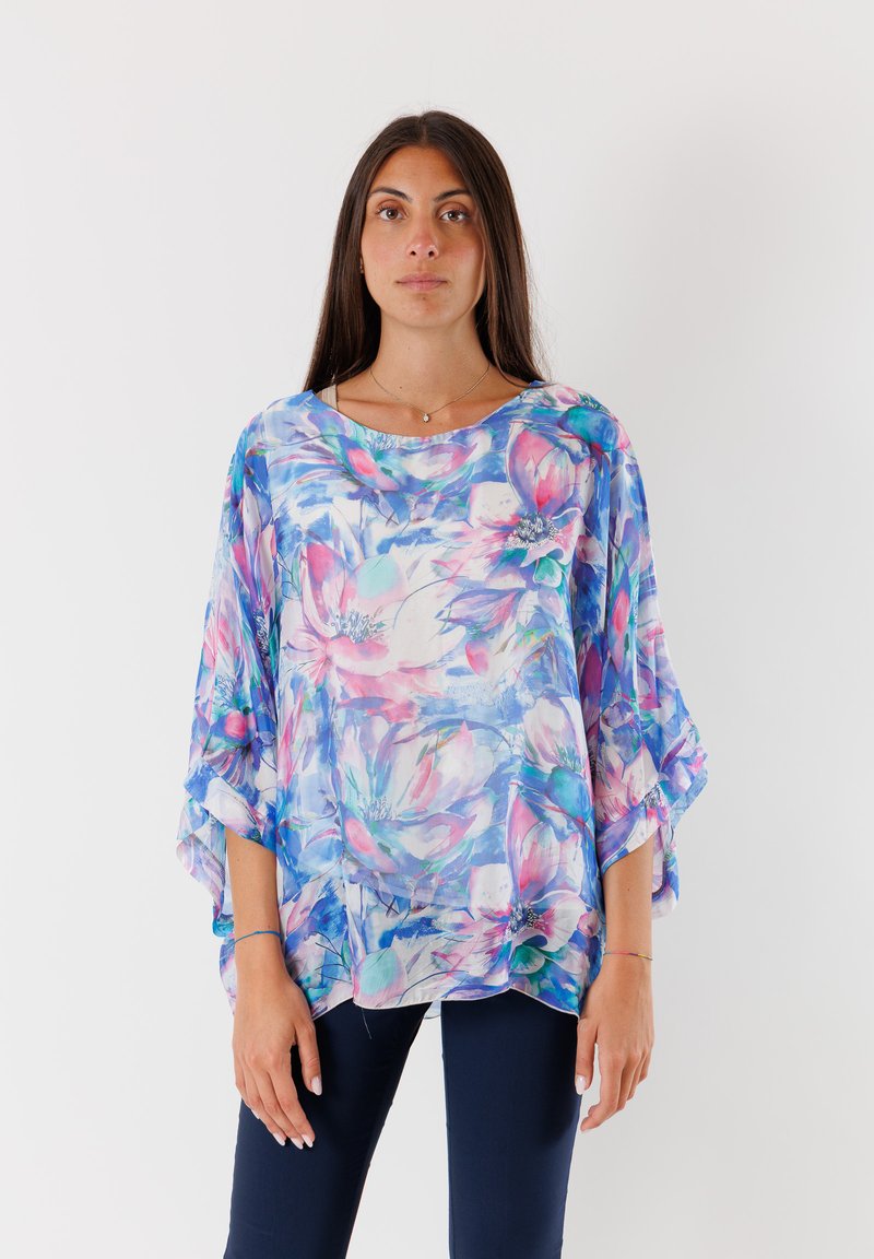 Blusa fluida e trasparente con un vivace motivo floreale nei toni del rosa e del blu, scollo rotondo e maniche ampie a pipistrello. Tessuto leggero.