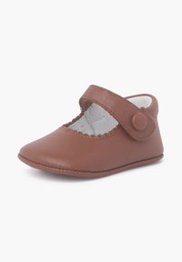 Brown leather Mary Jane shoe with a round toe, scalloped edge, and adjustable strap featuring a button accent. Soft white interior lining.