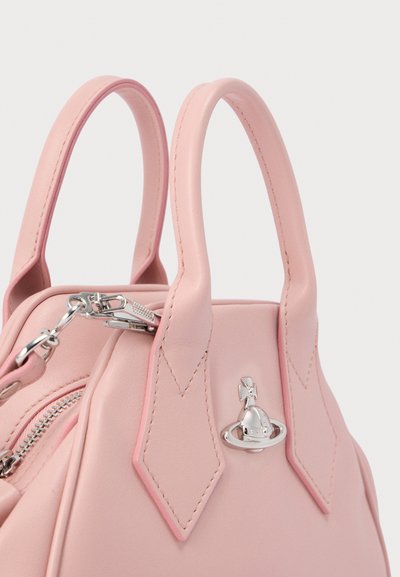 Ροζ δερμάτινη γυναικεία τσάντα με δύο επάνω χερούλια, ασημένια μεταλλικά στοιχεία και κλείσιμο με φερμουάρ. Διαθέτει σχηματισμένες, ραμμένες λεπτομέρειες στα πλαϊνά.
