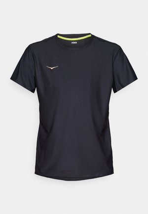 Melna sporta kreklis, izgatavots no teksturētas auduma, ar īsām piedurknēm, apaļu izgriezumu un mazu dzeltenu logotipu uz krūšu daļas.