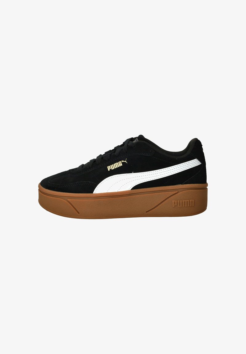 Sorte ruskinds sneakers med hvid side-stribe og guld logo, der har en tyk brun gummiplatform sål og flade snører.