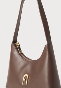 Borsa a spalla in pelle marrone con chiusura a zip dorata e dettaglio logo. Presenta una texture liscia e un design curvo. Le maniglie sono sottili e cucite.