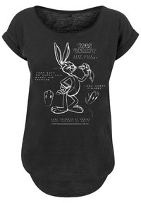 Melnā T-kreklā ar brīvu, noapaļotu kakla izgriezumu, kurā attēlots balts zīmējums ar Bugs Bunny un teksts par varoņu dizaina elementiem.
