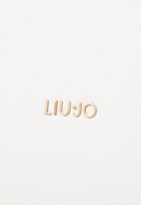 Witte leren oppervlakte met een gestructureerde afwerking, voorzien van een gouden "LIU JO" logo. Minimalistisch ontwerp met strakke, schone lijnen.