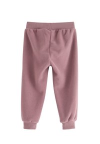 Fleece joggerbukser i blød støvet lyserød med elastisk talje og manchetter. Glat tekstur og løs pasform for komfort.