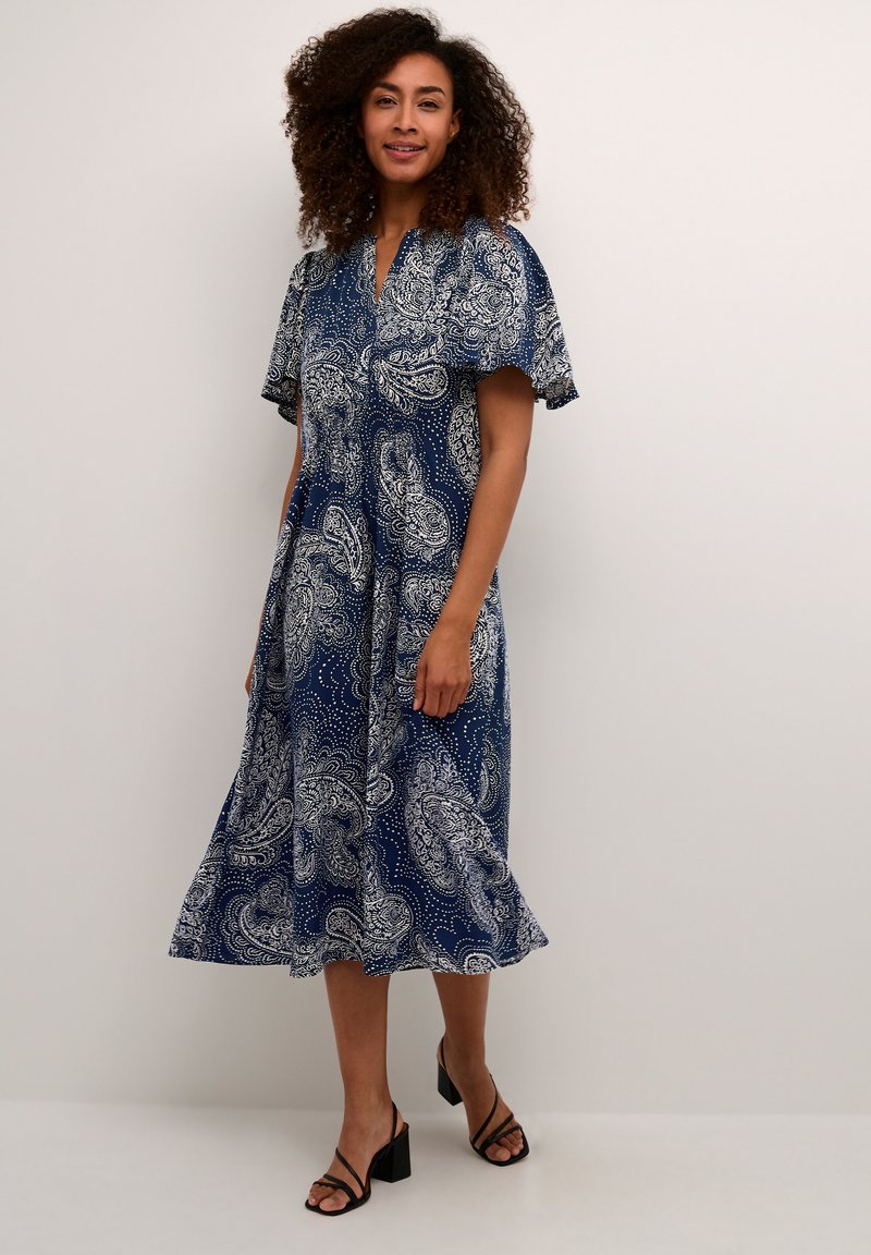 Abito blu navy con stampa paisley, maniche a palloncino corte e colletto, caratterizzato da una silhouette fluida, foderata e lunghezza a metà polpaccio.