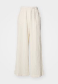 Cream wide-leg pants made of textured fabric with an elastic waistband and two side pockets, featuring vertical ribbed pattern.